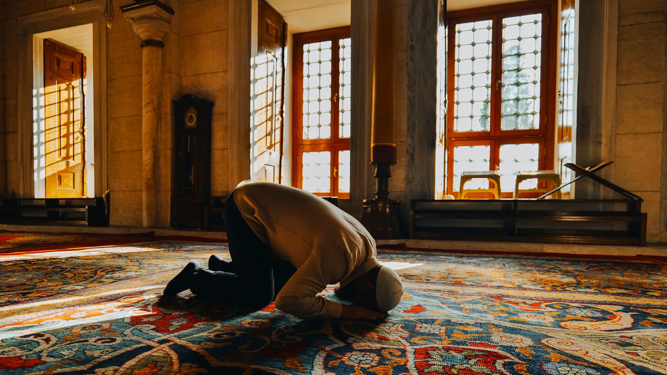 Siluet orang shalat di masjid saat golden hour